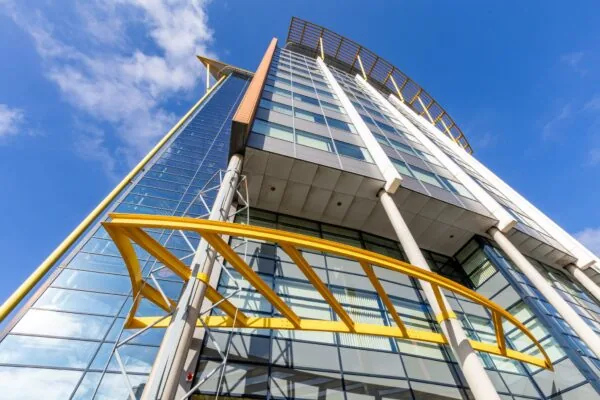 Hoog modern kantoorgebouw aan de Karel Doormanweg met opvallende gele accenten en glazen gevel, schuin van onderen gefotografeerd.